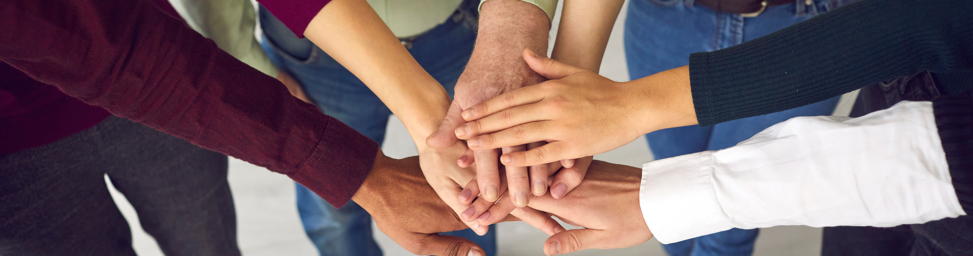 A group of hands forming a circle, symbolizing unity or collaboration.