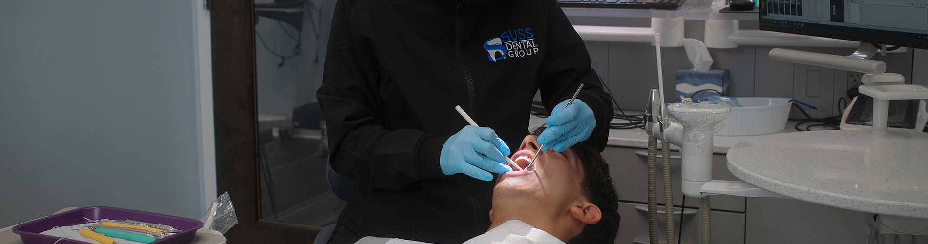 The image shows a modern dental clinic interior with various pieces of equipment, including a dental chair and an X-ray machine.