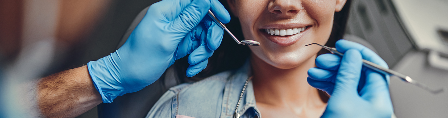 The image shows a group of people, possibly professionals given their attire and the setting that appears to be an office or professional environment. They are gathered around a table with a laptop on it, engaged in what seems to be a discussion or meeting.