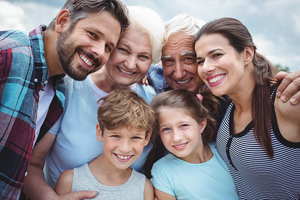 This image features a group of people, including an older couple and two children, posing for a photo together with smiles on their faces.
