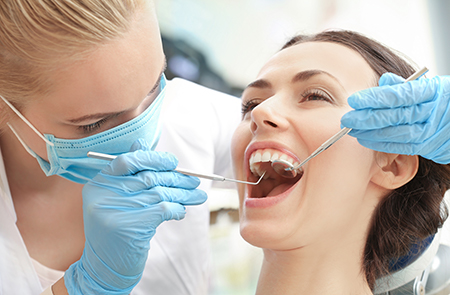 A dental hygienist performing a teeth cleaning procedure on a patient.